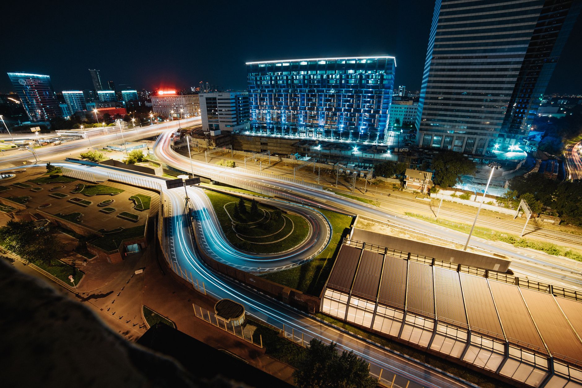 Multi-lane arterial highway corridor lined with modern glass corporate skyscrapers.