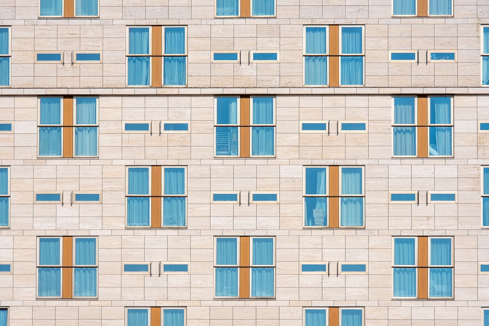 Contemporary luxury hotel facade featuring geometric architectural lines and expansive reflective glass panels.