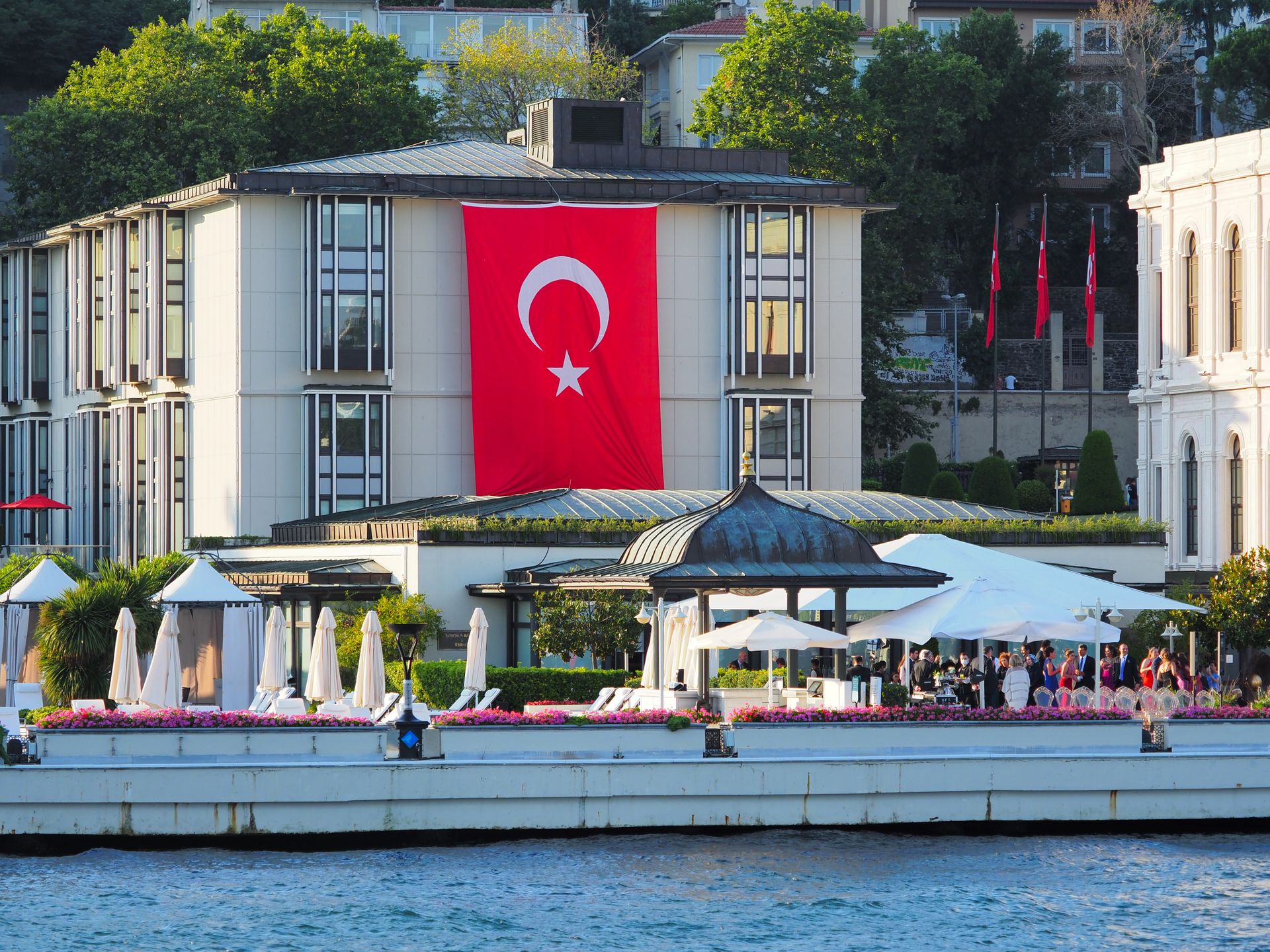 Panoramic waterfront view of the historic Four Seasons Hotel Istanbul at the Bosphorus with terrace along the strait.
