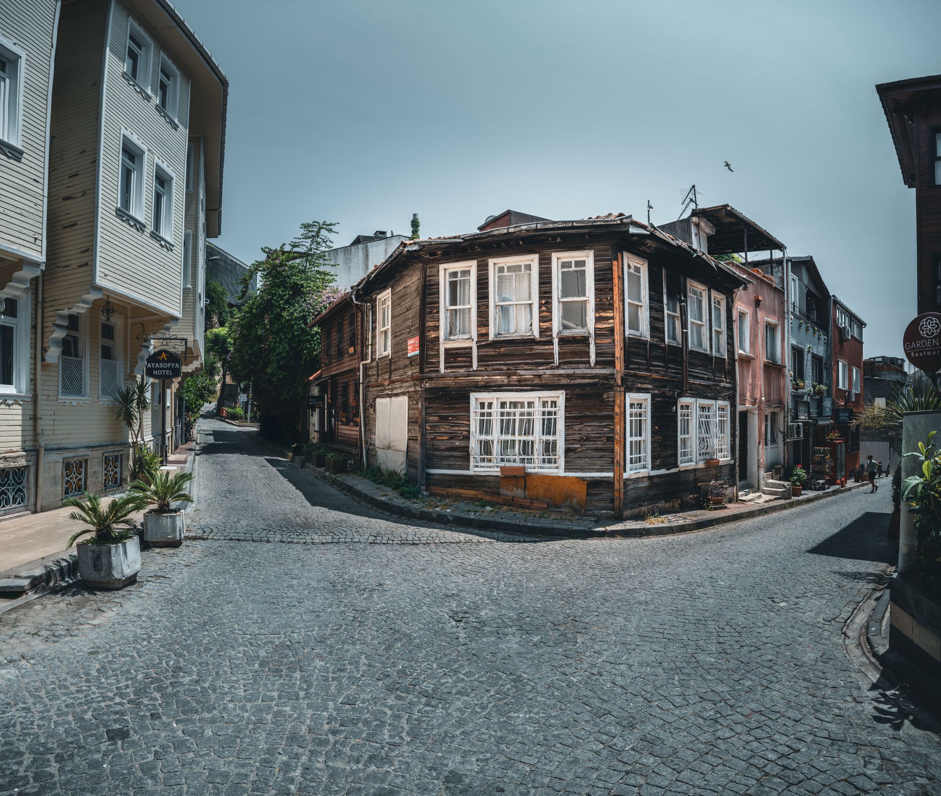 Charming cobblestone street flanked by historic multi-story Ottoman wooden mansions in the historic core of Istanbul.