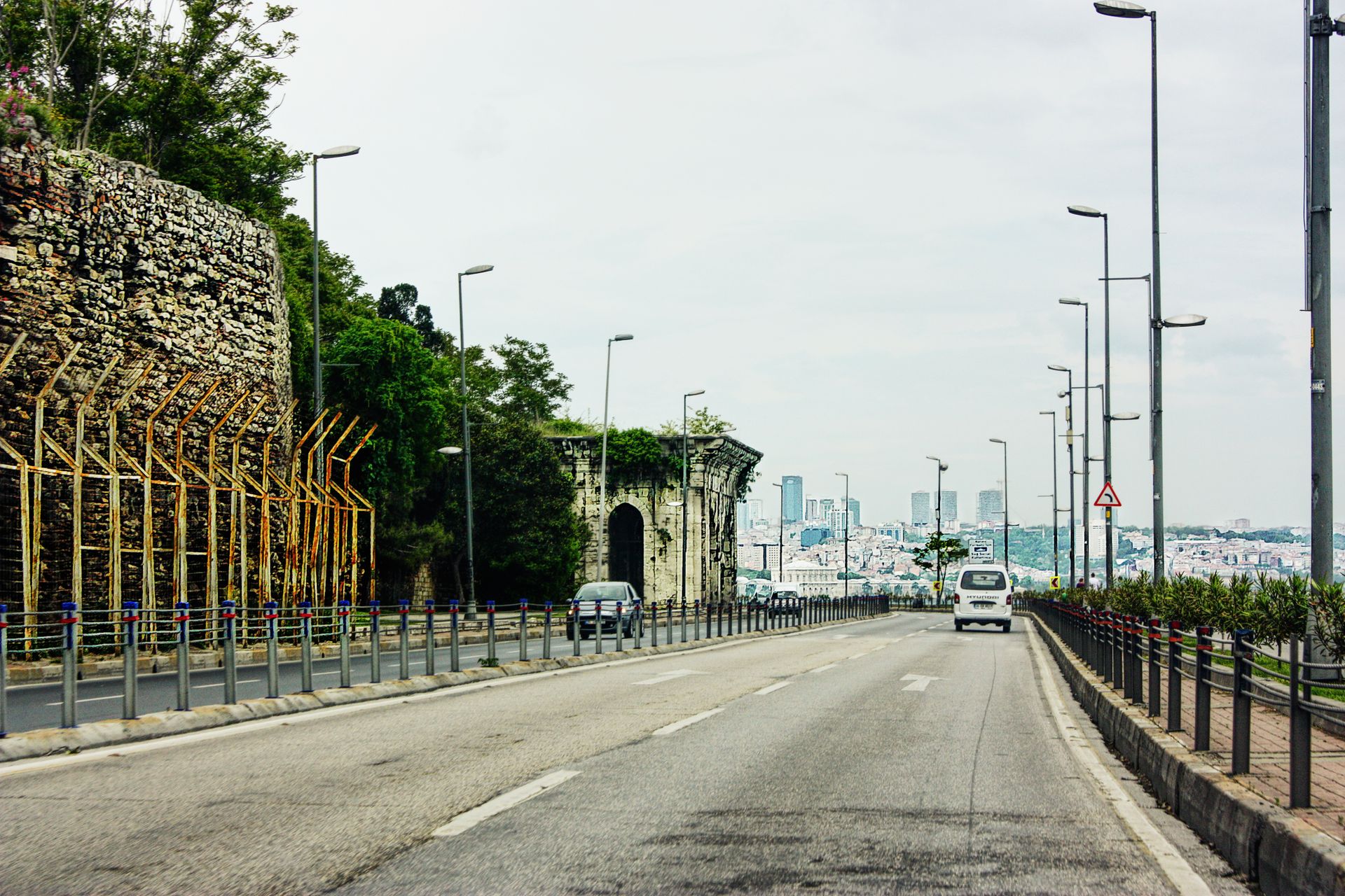 Ancient Theodosian stone sea walls and towers overlooking the Marmara coastal highway and Istanbul cityscape.