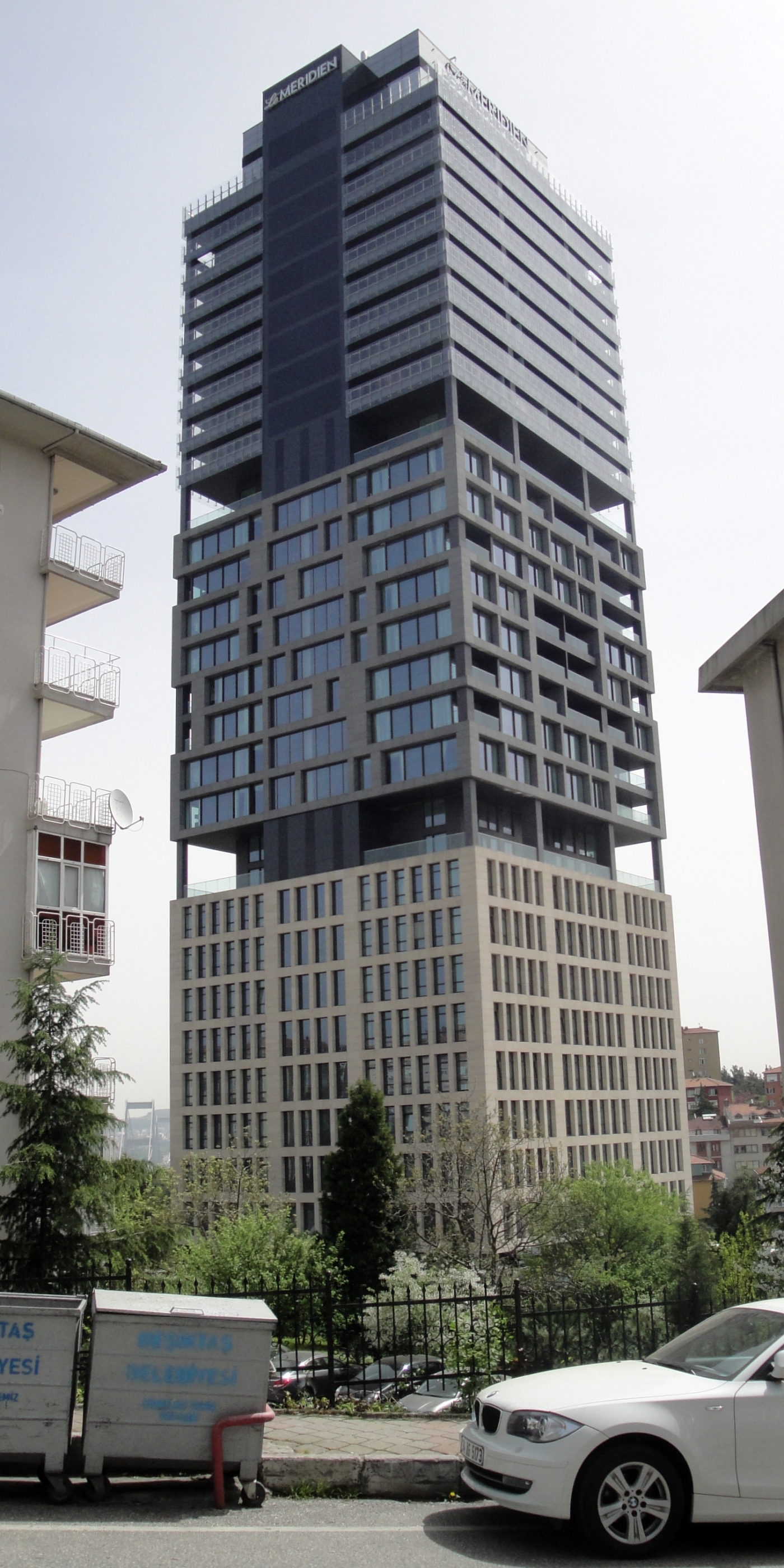 High-rise architectural glass tower of Le Méridien Istanbul Etiler rising above Cengiz Topel Caddesi.
