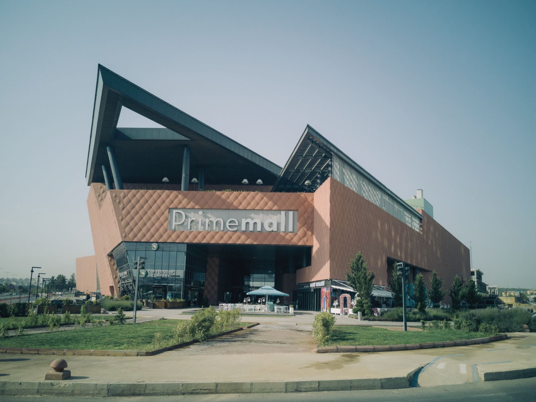 Striking contemporary shopping mall complex and residential towers under a clear sky.