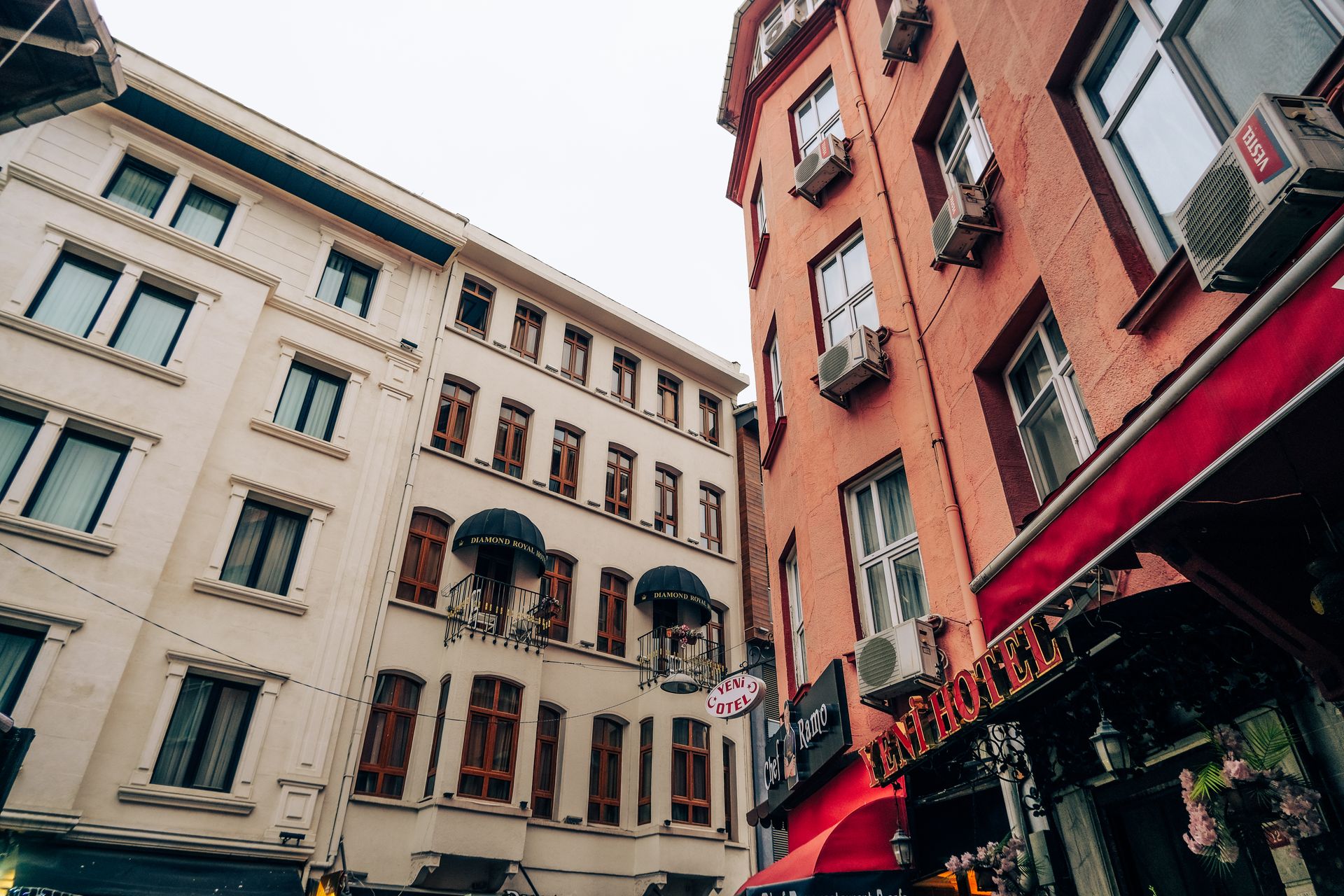 Low-angle street view of an urban boutique hotel building with classical facade details in Istanbul.