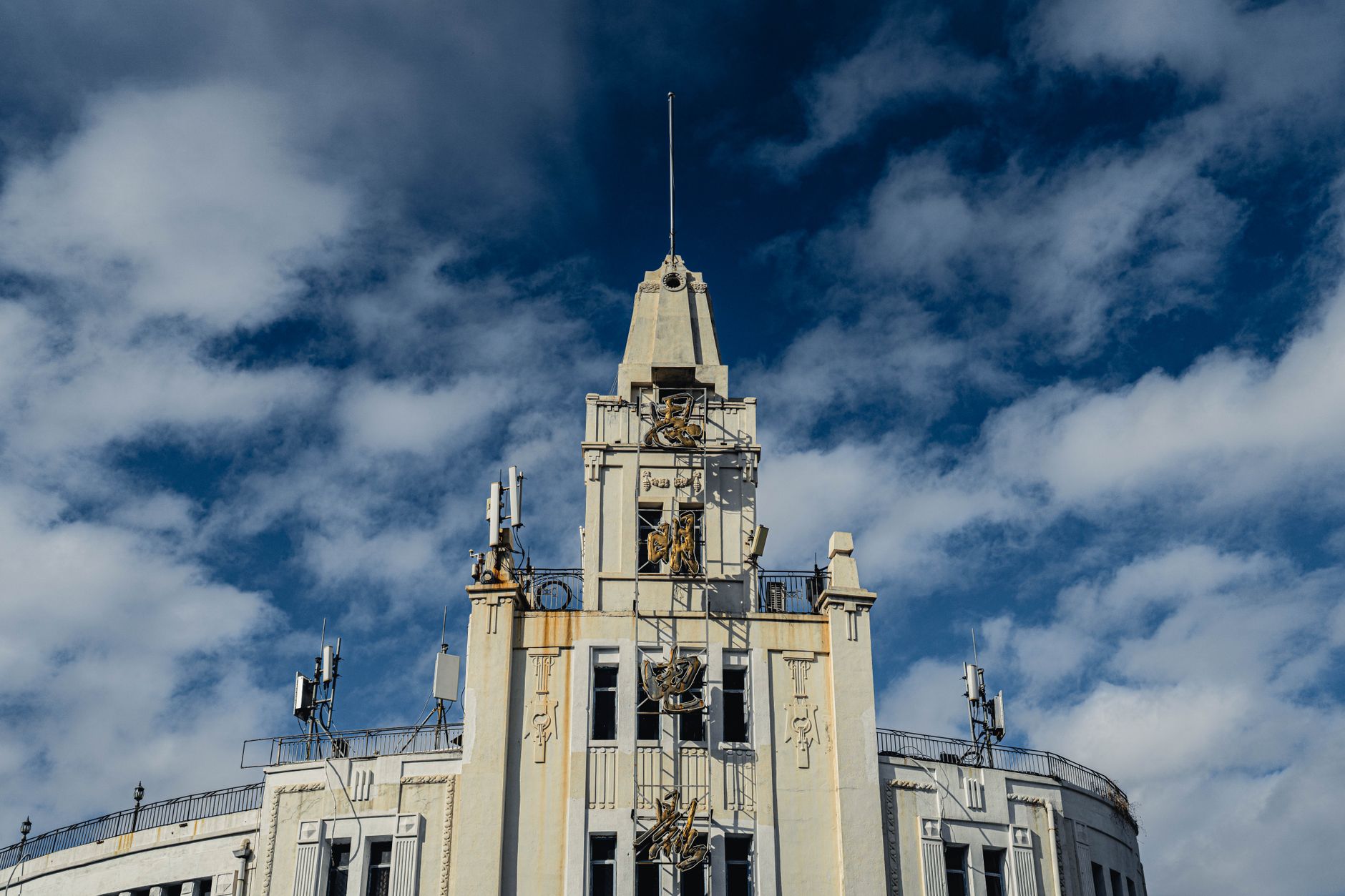 Historic 1920s Art Deco palazzo building facade featuring classical stone carvings and balconies.