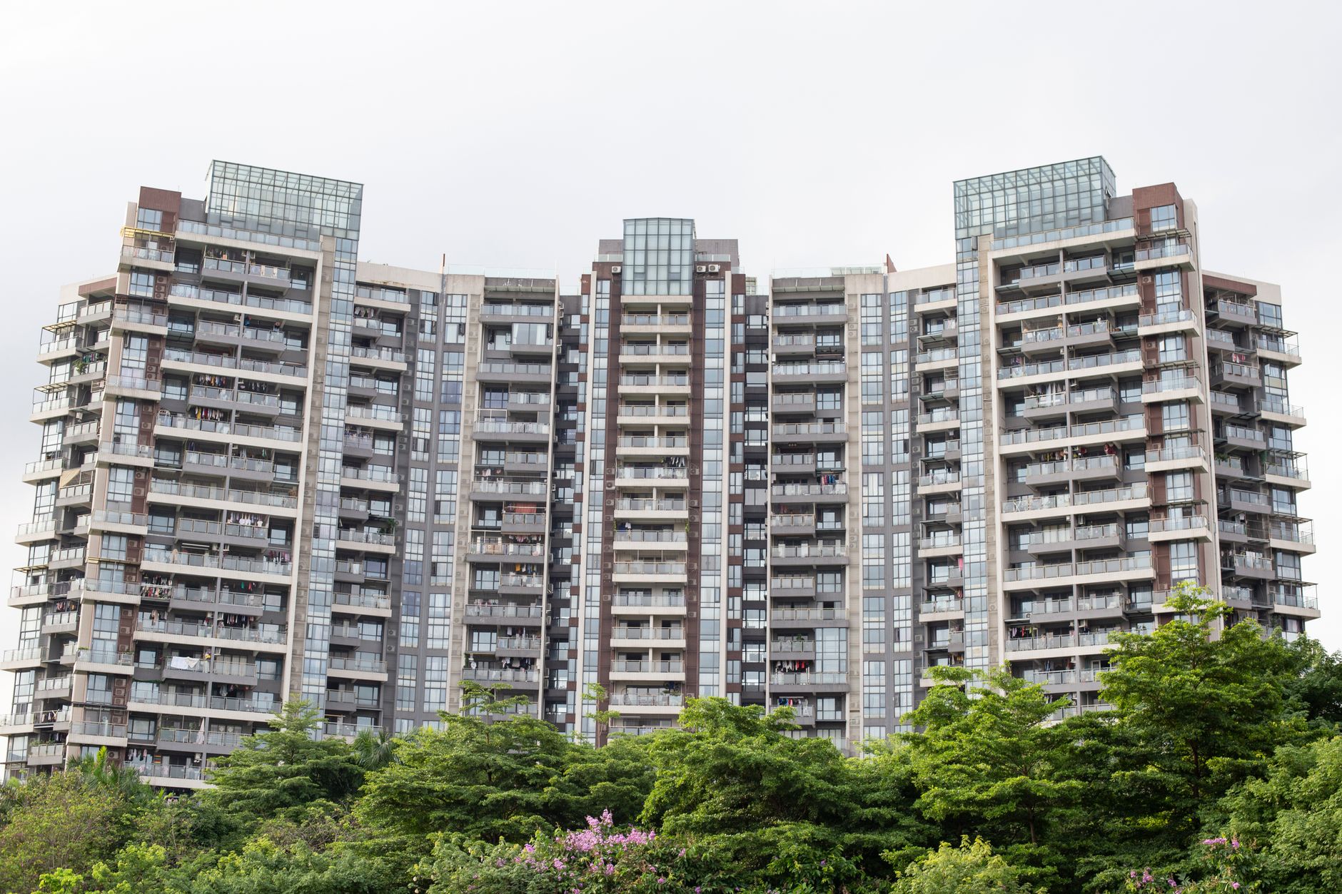 Towering contemporary serviced apartment skyscraper with modern architectural geometric lines.