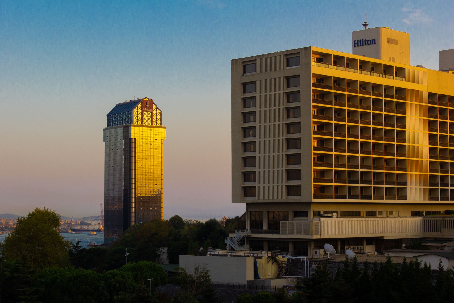 Elevated view of luxury hotels and green parkland in Maçka and Dolmabahçe overlooking the Bosphorus at sunset.