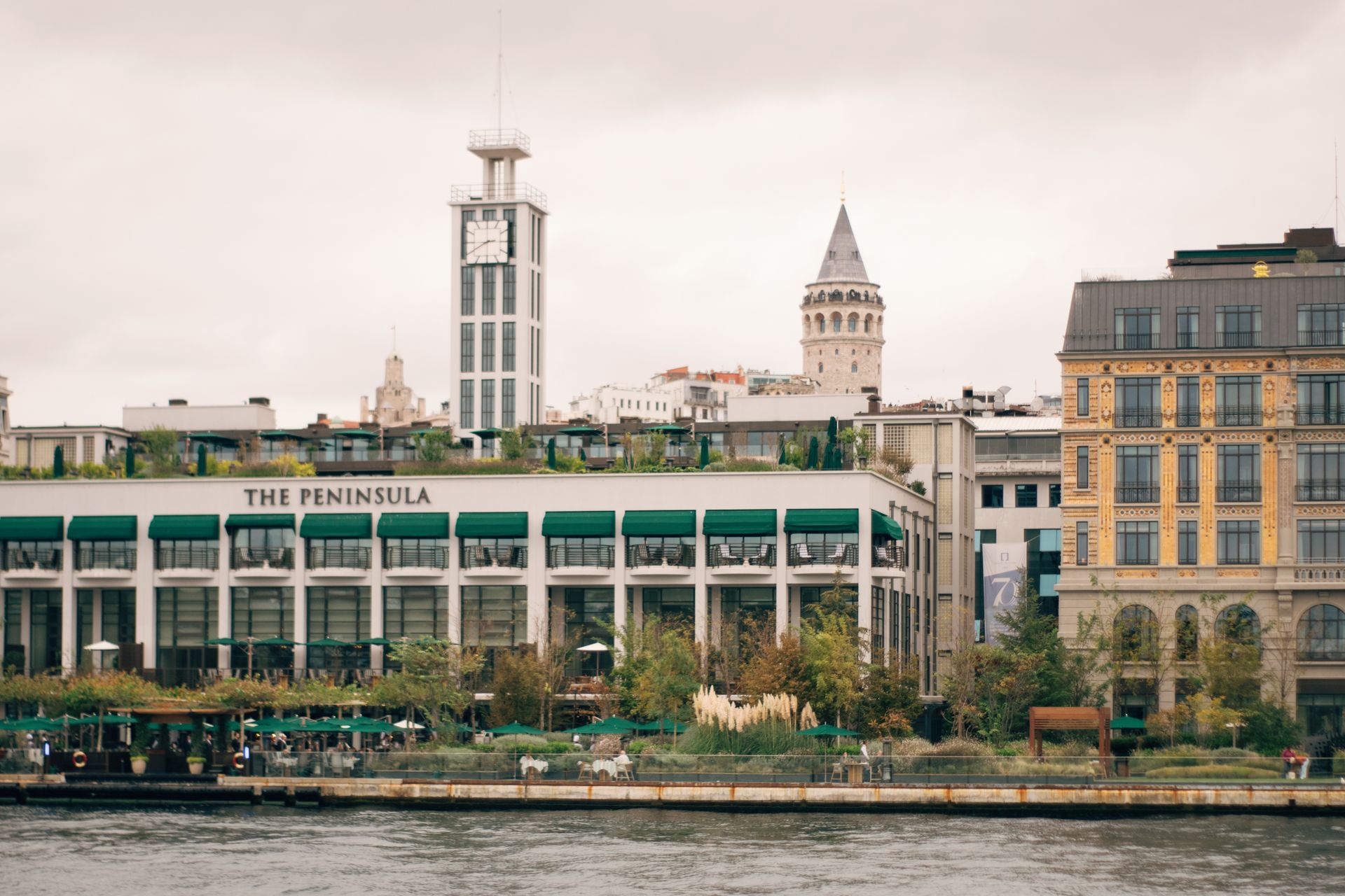 View from the Bosphorus showing The Peninsula Istanbul waterfront hotel buildings and Galata Tower in Karaköy.