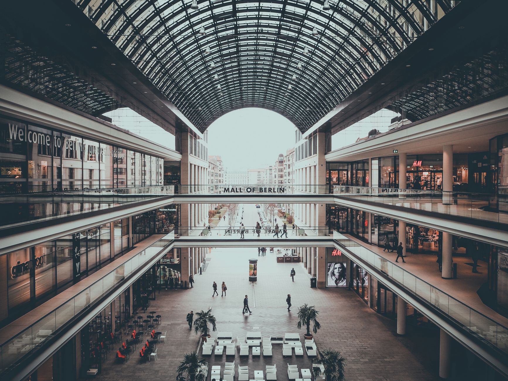 Expansive modern commercial shopping promenade and high-rise complex with elevated transit infrastructure.