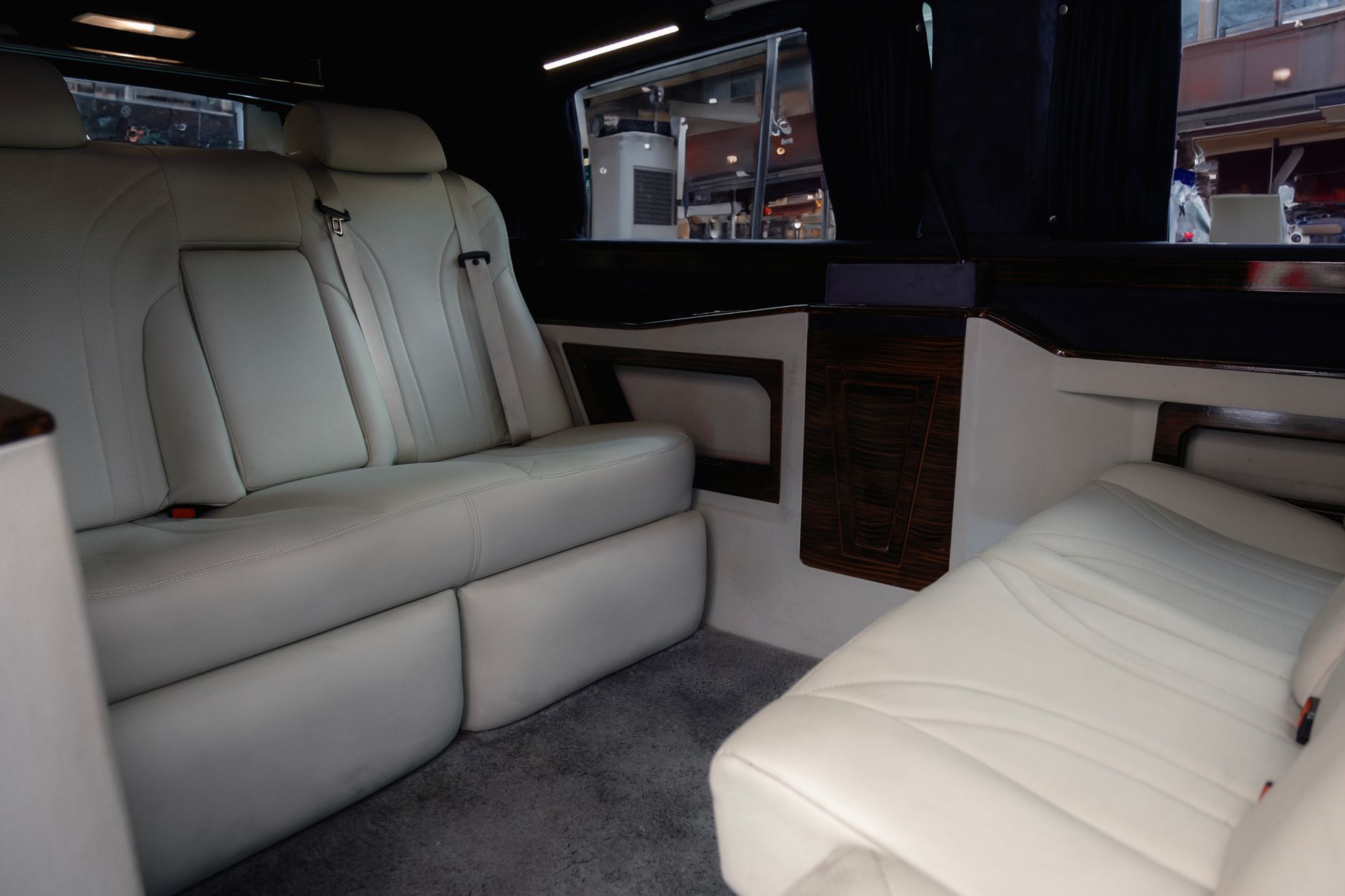 Luxurious custom leather executive seating and ambient mood lighting inside a premium Mercedes Vito VIP transfer vehicle.