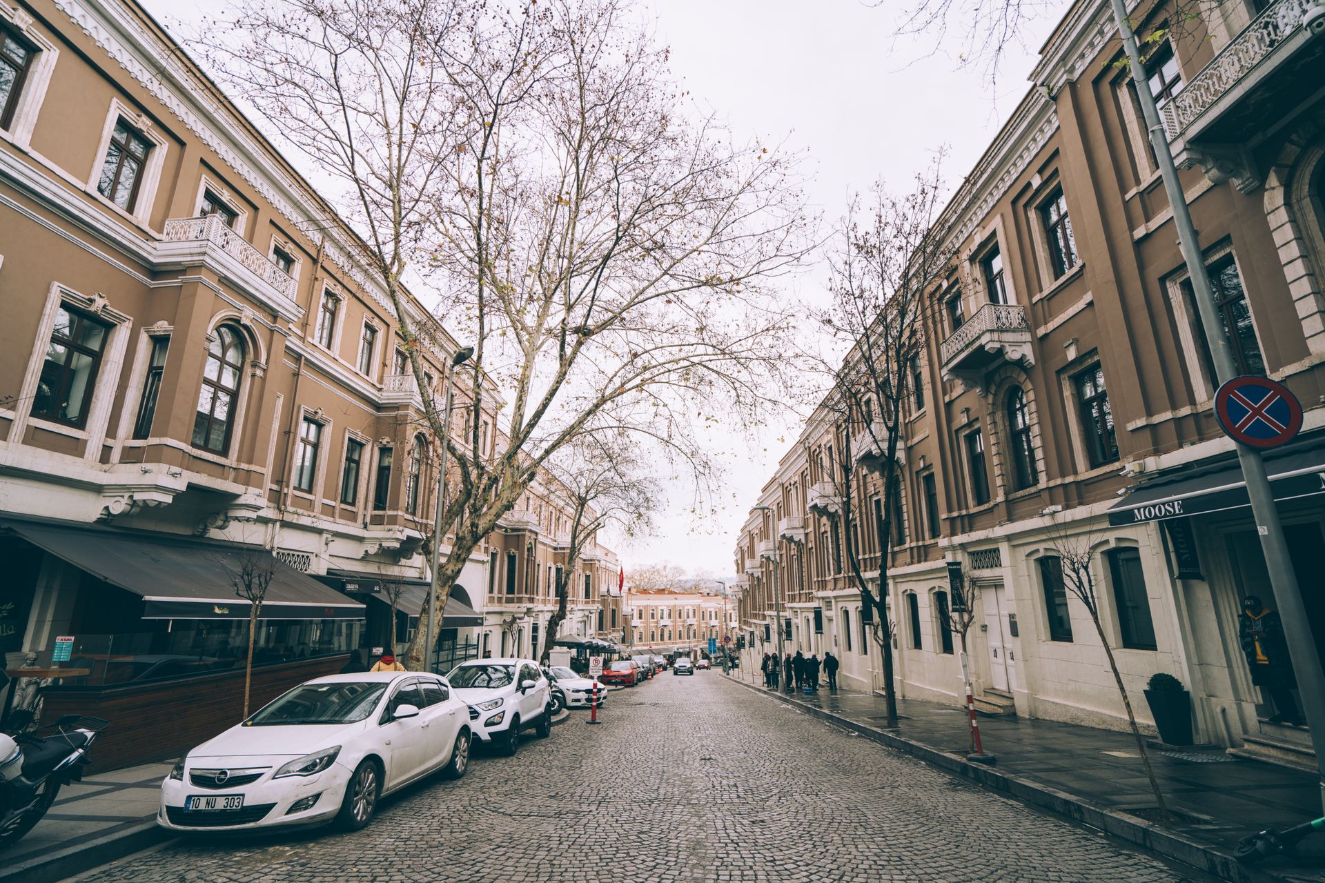 Upscale urban shopping street in Istanbul lined with stylish boutique storefronts and classic residential buildings.